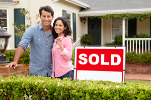 Couple next to sold sign